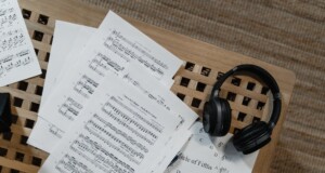 partituras, auricular y círculo de quintas sobre un atril de madera