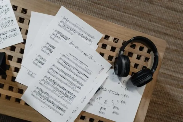 partituras, auricular y círculo de quintas sobre un atril de madera