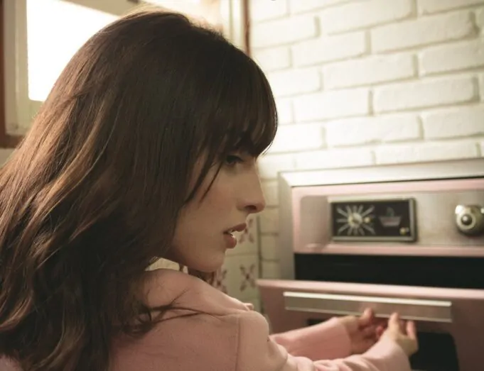 chica abriendo horno rosa