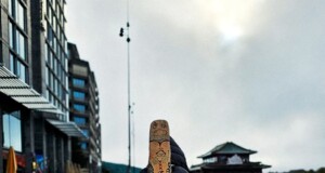musician walking with guitar by waterfront