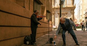 man playing violin on a street